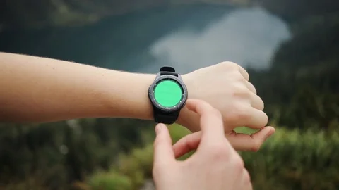 Close up man hands gestures on a round screen modern smartwatch with a green Stock Footage 95450548