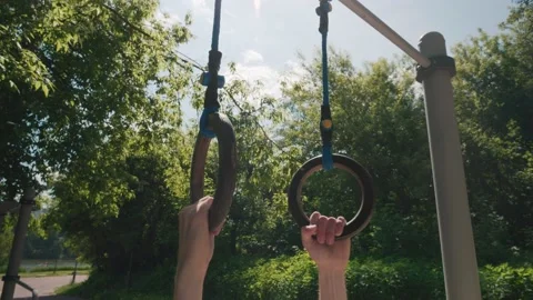 Close-up of man hands hanging and swinging on gymnastic rings back and forth Video stock 201358325