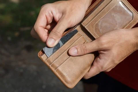 CLose up of a man hands as he is getting a credit card out of his wallet Stock Photos