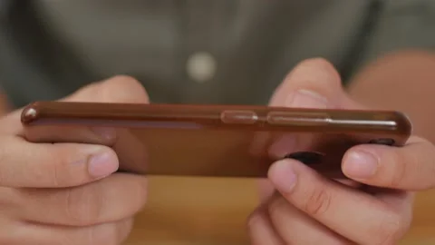 Close up of man hands holding and using smart phone to play online game Stock Footage 141573358