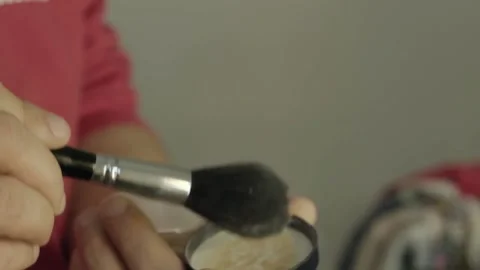 Close-up of man hands holding and shaking face powder from a brush. Stock Footage 169384490
