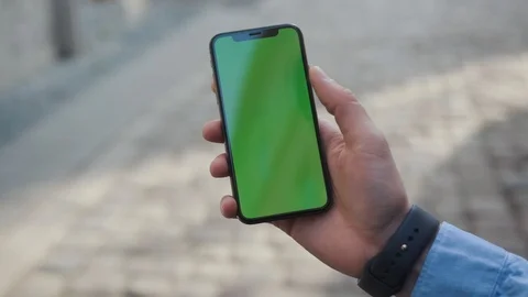 Close up man hands holding a smartphone with vertical green screen background Stock Footage 108073634