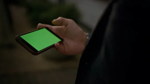Close up man hands holding smartphone with green screen. Male professional Video stock 131598529