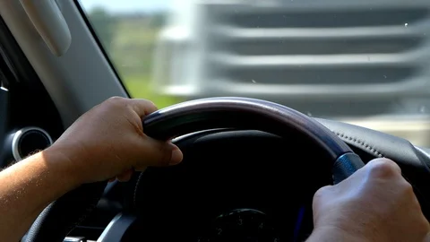 Close up of man hands holding steering wheel and driving luxury car. Stock Footage 125054981
