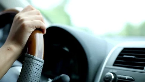 Close-up of man hands holding on steering wheel while driving a car in sunny Stock-Footage 336265361
