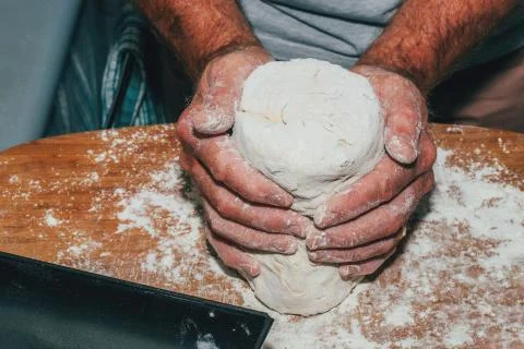 Close-up of man hands kneading bread dough on a cutting board Stock Photos