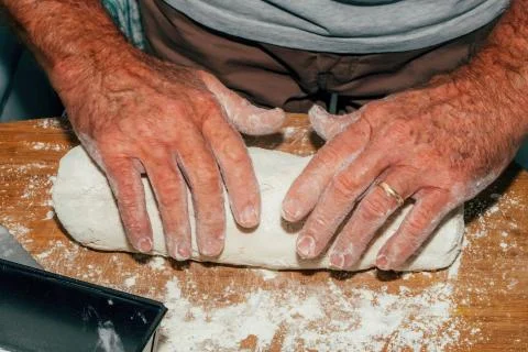 Close-up of man hands kneading bread dough on a cutting board Stock Photos