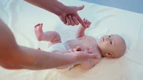 Close up to man hands make feet and sole massage to baby Video stock 121682355