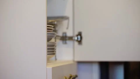 Close-up of man hands opens a kitchen cupboard with clean dishes and takes Stock Footage 282529946