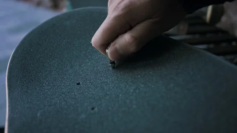 Close-up Of Man Hands Poking A Hole In The New Grip Tape On His Skateboard Stock Footage 133624669
