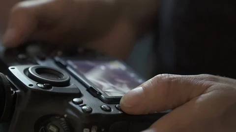 Close up of man hands pushing buttons on camera and checking the photo Видео 119888619