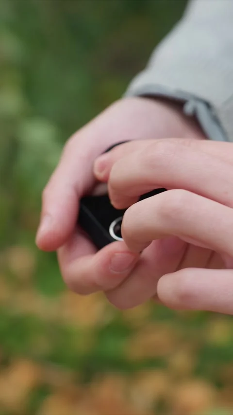 Close up of man hands revealing engagement ring in black box outdoors with Stock Footage 346236126