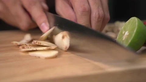 Close-up of Man hands slice galangal in pieces on cutting board Stock Footage 141096221