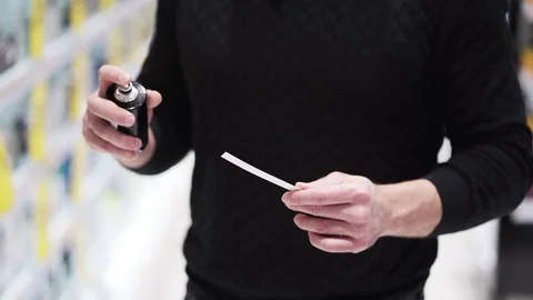 Close up, man hands sprays perfume on tester and sniffs it at cosmetics store Stock-Footage 121773359