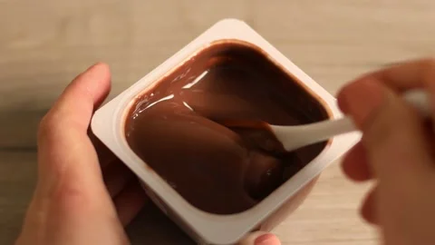 Close up of man hands take a delicious chocolate mousse or pudding with spoon in Stock Footage 150177213