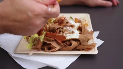 Close up man hands taking street food with fork from paper plate Video stock 253268923