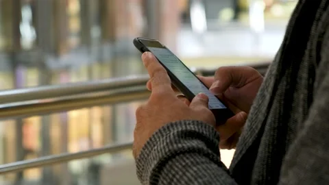 Close up of man hands texting a message on shopping mall background. Media. Male Stock Footage 139565831