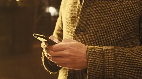 Close up of a man hands texting on phone in a winter night in the street Stock Footage 156191057