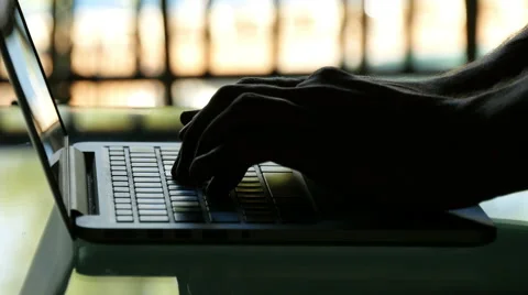 Close up of man hands typing on a laptop keyboard at sunset Video stock 48039318