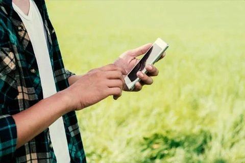 Close-up of man hands using his smartphone outdoor in the park. Stock Photos