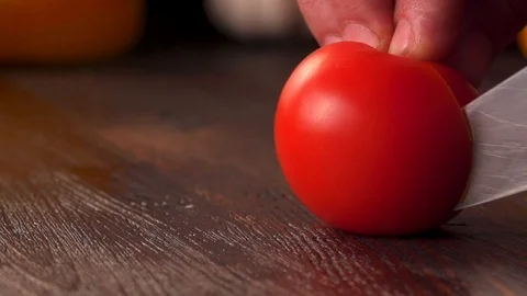 Close up man hands using kitchen knife cutting fresh tomato on wooden cutting Stock Footage 120305595
