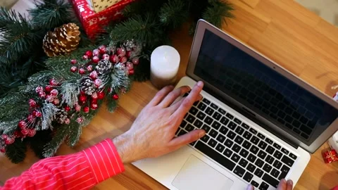 Close-up of man hands using laptop keyboard. Christmas decoration on background. Vidéo 146304160