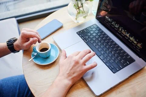 Close up of man hands using laptop trackpad with espresso cup, coding or wo.. Foto stock