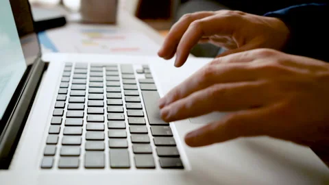 Close-up of man hands working and typing on laptop keyboard on wooden table Stock Footage 130173671