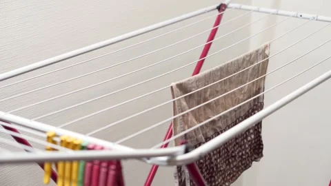 A close-up of a man hanging laundry on a clothesline after washing. Video stock 251835916