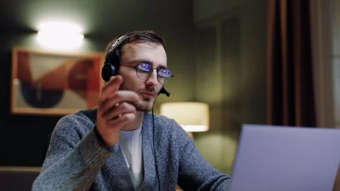 Close up of man in headphones using laptop computer communicates via video chat Video stock 263130710