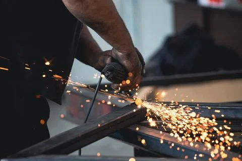 Close up on a man held an angle grinder to cut an iron with sparks Stock Photos