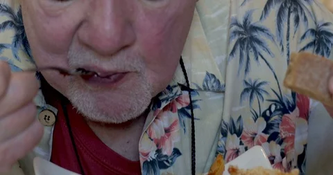 Close up of a man in his 70s or 80s eating a bowl of penne pasta Stock Footage 88013597