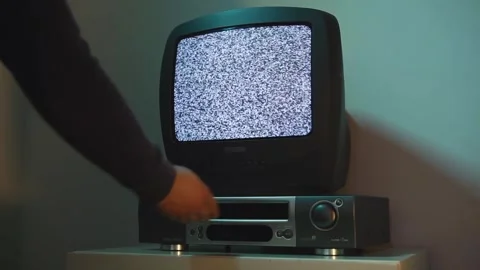 Close-up of man with his hand inserting VHS for viewing on an old TV with noise Vídeo Stock 266201944