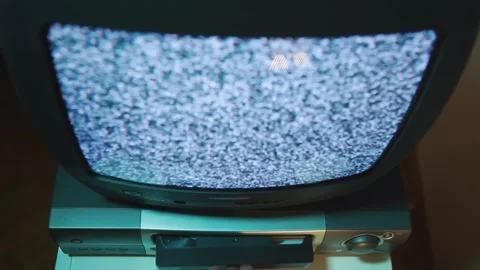 Close-up of man with his hand inserting VHS for viewing on an old TV with noise Vídeo Stock 266201989