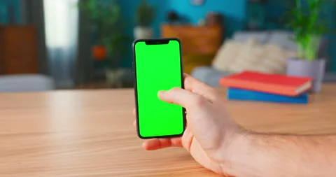Close-up of a Man Holding and Making Hand Gestures on a Modern Green Mock-up Stock Footage 154854892