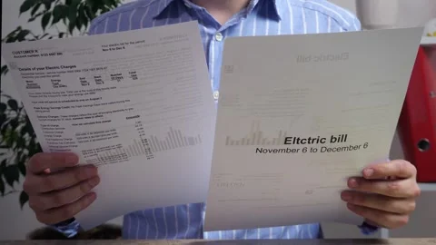 A close-up of a man holding a bill, reading it and looking at the money. Stock Footage 310058091