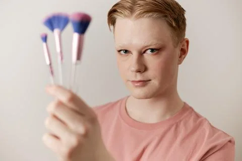 A Close-up of a Man Holding Makeup Brush Posing with Finished Look Stock Photos