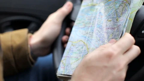 Close-up, a man holding a map and driving a car 스톡 동영상 88879519