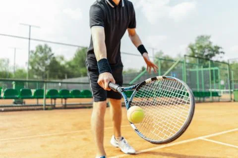 Close up of man holding racket at right hand and beating a tennis ball. Foto stock