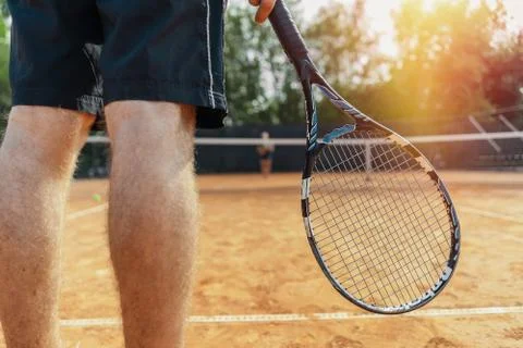 Close up of man holding racket while waiting for ball serving at tennis court. Foto stock