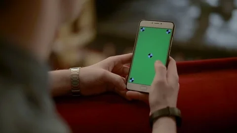 Close Up Man Holding Smartphone slide Touch With Green Screen in the Theatre Stock Footage 73564912