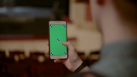 Close Up Man Holding Smartphone slide Touch With Green Screen in the Theatre Stock Footage 73564940