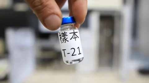 A close up from a man holding a vial with a liquid labelled as sample in chinese Vídeos de archivo 254600547