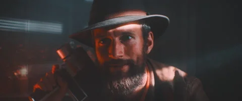 Close up of man holding vintage camera wearing hat looking into camera Stock Footage 203567142