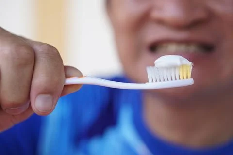 Close up man holds toothbrush with toothpaste. Concept, dental health care. Stock Photos