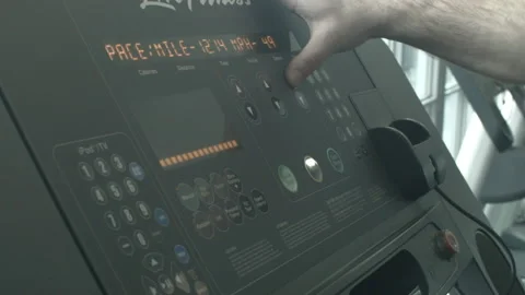 Close Up of a Man Increasing the Speed Level on a Treadmill Stock Footage 233853912
