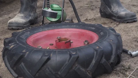Close up of man inflating tyre for a motor cultivator with a foot pump. Video stock 129778135