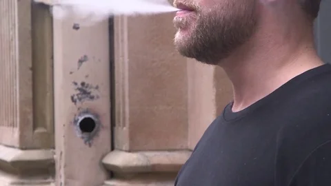 Close-up of man inhaling an e-cigarette vaping device asian Stock Footage 120652378