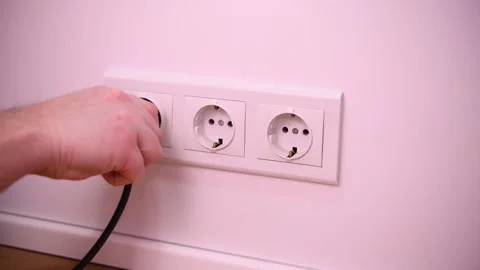 Close-up of a man inserting an electrical plug into a socket. Stock Footage 302540789
