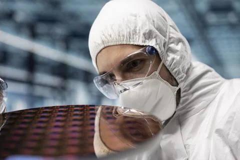 Close up of man inspecting microelectronic silicon wafer components Stock Photos